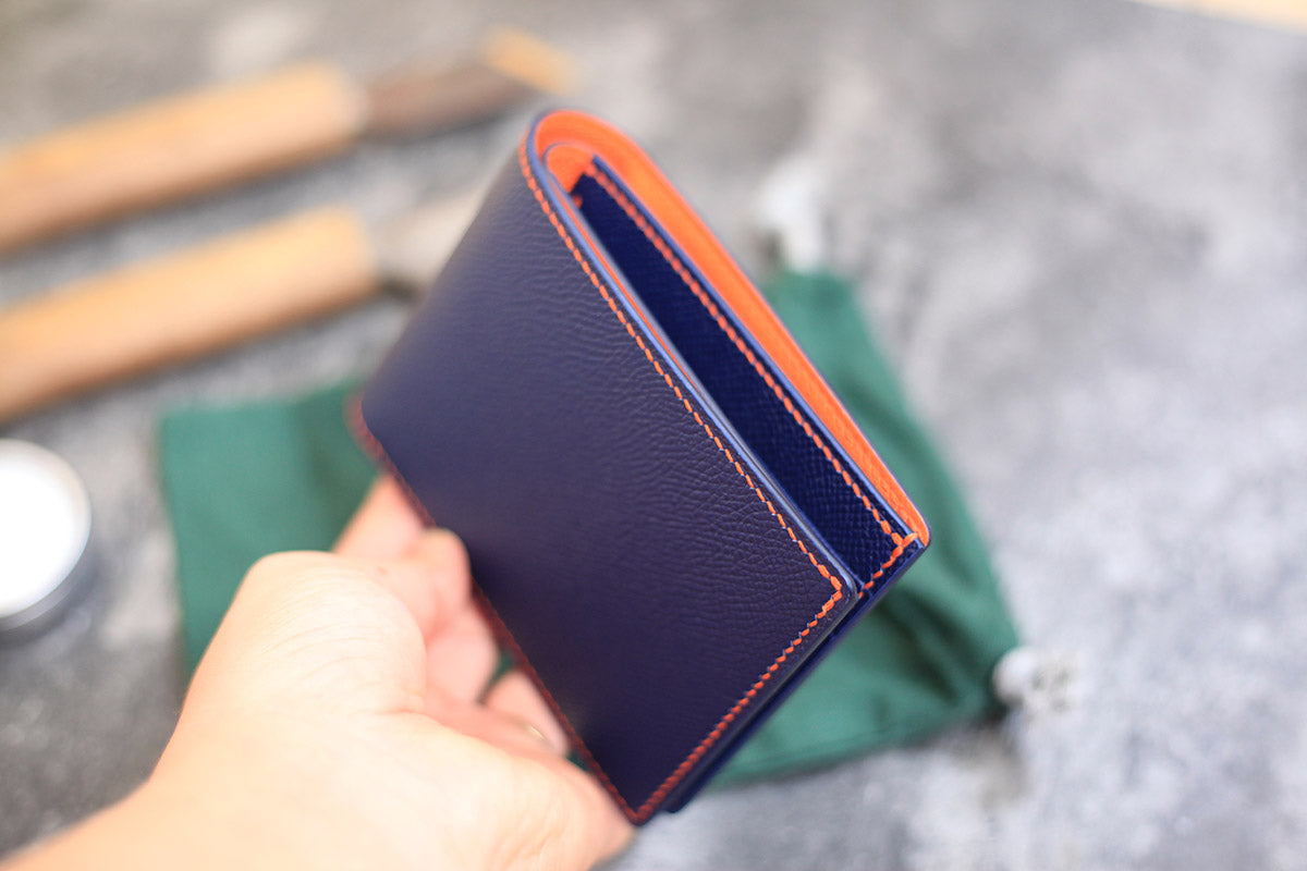 dark blue and orange leather bifold wallet.